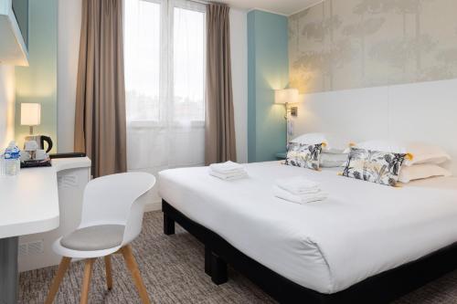 a hotel room with a large bed and a chair at Hôtel Byakko Nice in Nice