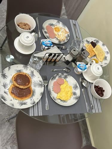 a table with plates of breakfast food on it at Chambres d'Hôtes Centre Ville in Dakar