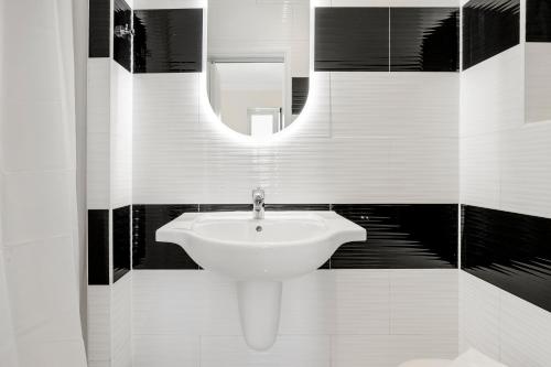 a bathroom with a white sink and a mirror at London Star Hotel in London