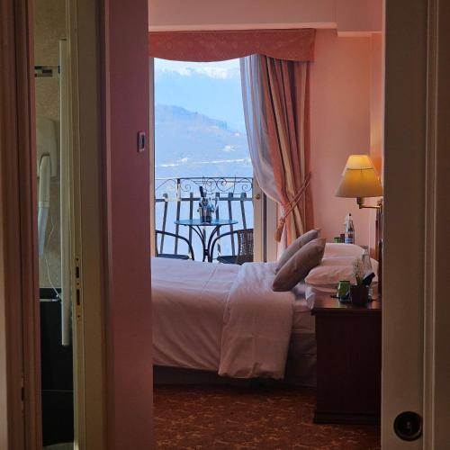 a bedroom with a bed and a view of a balcony at Hotel Funicolare in Lanzo dʼIntelvi