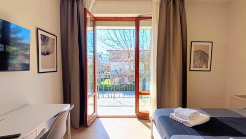 a bedroom with a bed and a sliding glass door at I Marosi Beach Apartment in Lido di Fermo