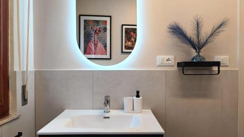a bathroom with a white sink and a mirror at I Marosi Beach Apartment in Lido di Fermo