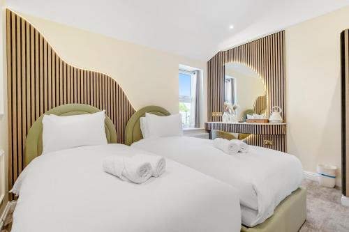 two beds in a room with a mirror at London Star Hotel in London