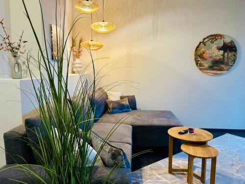 a living room with a couch and a table at Deluxe Apartment im Grünen mit Balkon und Frühstück im Hotel Reindahls in Wilkendorf