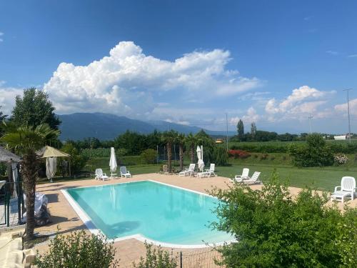 a swimming pool in a yard with chairs and a mountain at Residence Nonna Giuseppina in Casoni