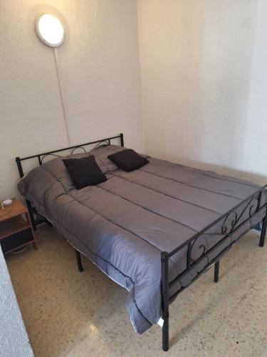 Cette chambre comprend un grand lit et une lampe. dans l'établissement Appartement proche des thermes, à Balaruc-les-Bains