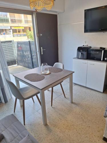 a table and chairs in a room with a television at Appartement proche des thermes in Balaruc-les-Bains