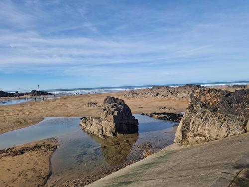 a rock formation in the sand on a beach at Bude Holiday Resort Peace And Quiet in Bude