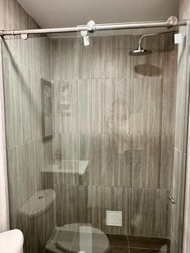 a shower with a glass door with a person in it at Apartamentos cómodos en Milan zona G in Manizales