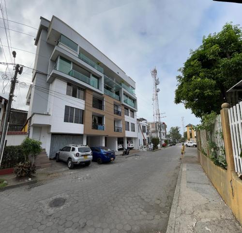 a street with a building and cars parked on the street at Apartamento Entero en Miramar 2 in Tumaco