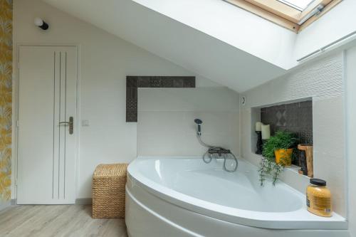 a white bathroom with a large tub in a room at La Maison de Papy Ours,Family ,Air-conditioned in Bourré