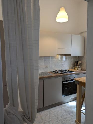 a kitchen with a curtain in front of a stove at Casa Vacanze con Piscina a 2 passi da Lecce P1 in San Pietro in Lama