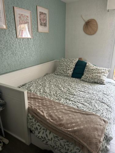 un petit lit dans une chambre avec un couvre-lit et un oreiller dans l'établissement Studio calme 4 personnes 400 m de la plage sur la presqu'île de St mandrier proche toulon, à Saint-Mandrier-sur-Mer