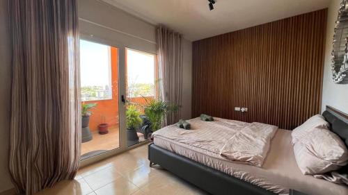 een slaapkamer met een bed en een groot raam bij Tropical in Durrës