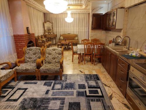 a kitchen and dining room with a table and chairs at شقة مفروشة في البنيات - بالقرب من جامعة البتراء in Amman