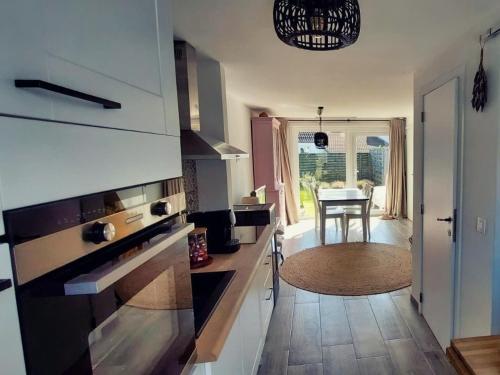 eine Küche mit Tisch und ein Esszimmer in der Unterkunft Salty - Vakantiehuisje op de grens van Bredene-De Haan in Bredene