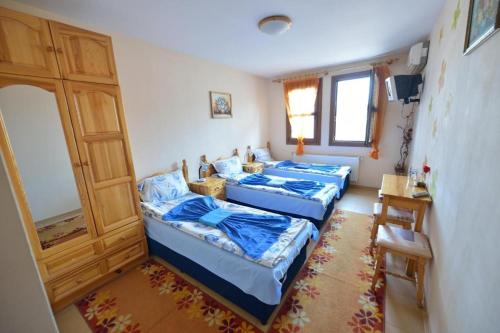 a room with three beds and a door at Family Hotel Varusha 2 in Veliko Tŭrnovo