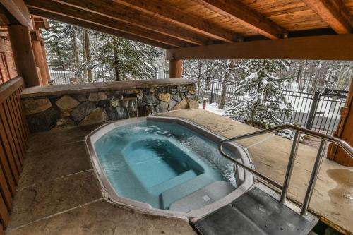 ein Whirlpool auf einer Veranda mit Terrasse in der Unterkunft Jack Pine 8008 by SummitCove Lodging in Keystone