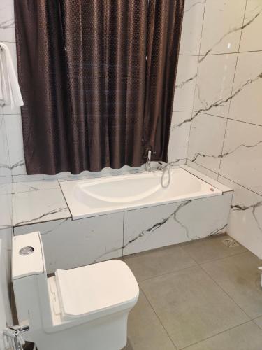 a bathroom with a toilet and a shower curtain at Robin's Paradise Deluxe Villa in Vagamon