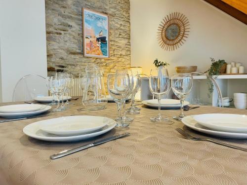 a table with glasses and plates on a table at Au Loysel Prestations de qualité au coeur de Cherbourg in Cherbourg en Cotentin