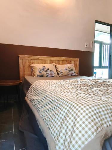 a bedroom with a bed with a checkered blanket at Long Homestay Mỹ Hạnh - Hotels in Ðức Hòa