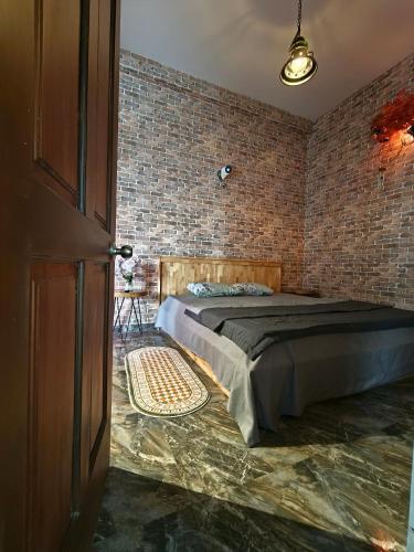 a bedroom with a bed and a brick wall at Long Homestay Mỹ Hạnh - Hotels in Ðức Hòa