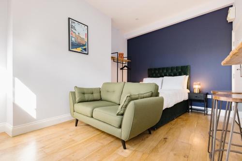 a bedroom with a bed and a green couch at Leicester Square Studios in London