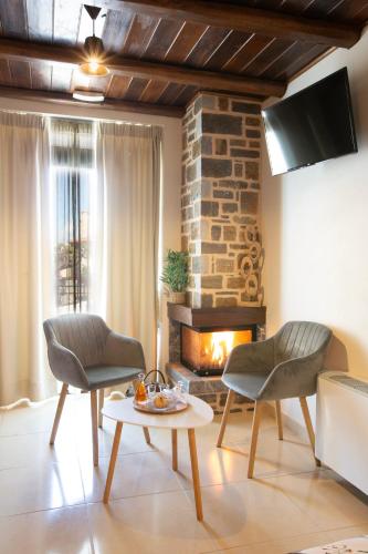 a living room with two chairs and a fireplace at Spiliara-Apartments in Axós