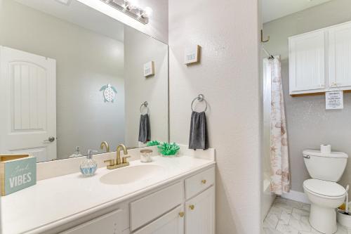 a bathroom with a sink and a toilet and a mirror at Walk to Crystal Beach Coastal Getaway with Deck in Crystal Beach