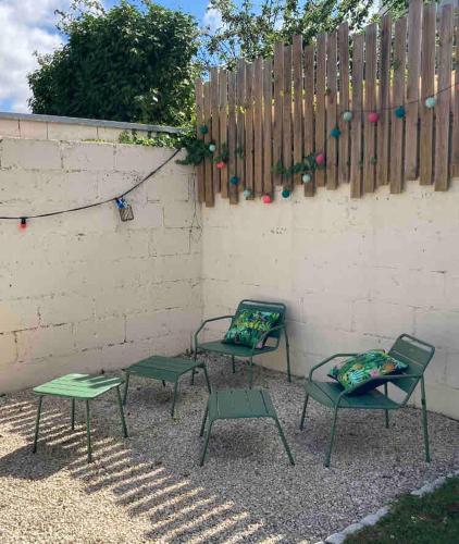 trois chaises vertes assises devant une clôture dans l'établissement maison indépendante, à Orvault