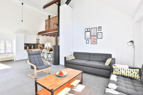 un salon avec un canapé et une table dans l'établissement le refuge fleuri T5 avec terrasse et jardin, à Brunstatt