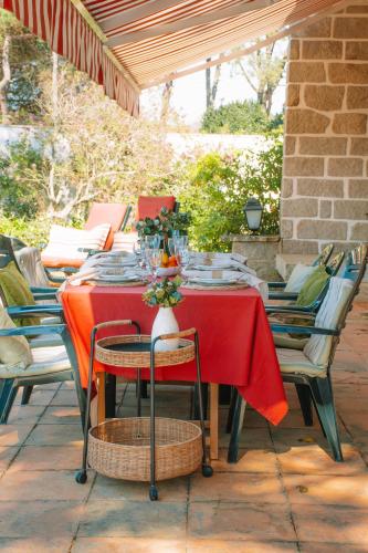 a table with a red table cloth on a patio at Just Like Home - Casa das Dunas in Moledo