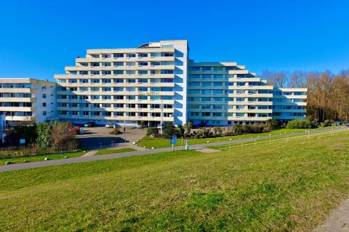 a large white building in front of a green field at Nautic 108 in Cuxhaven