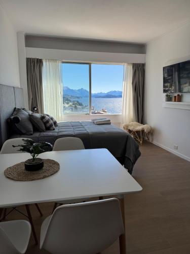 1 dormitorio con cama, mesa y ventana grande en Ideal Apartment in Bariloche, en San Carlos de Bariloche
