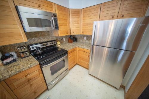 a kitchen with a stainless steel refrigerator and a microwave at Ski Run 202 by SummitCove Lodging in Keystone