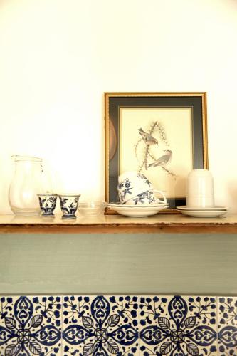 a shelf with blue and white plates and a picture at Boutique-Hotel Guesthouse Le Locle in Le Locle