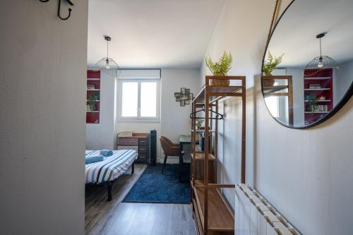 - une chambre avec un miroir, un lit et un bureau dans l'établissement le petit indus, à Angers