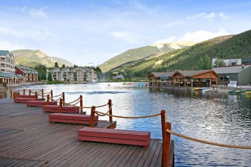 a river with a bunch of benches on a dock at Lakeside 1495 by SummitCove Lodging in Keystone