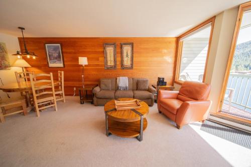 a living room with a couch and chairs and a table at Lakeside 1495 by SummitCove Lodging in Keystone