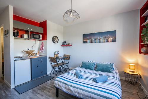 une chambre avec un lit avec des oreillers bleus dessus dans l'établissement le petit indus, à Angers