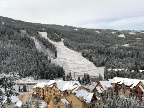 a ski resort with snow covered buildings and a mountain at Red Hawk Lodge 2297 by SummitCove Lodging in Keystone