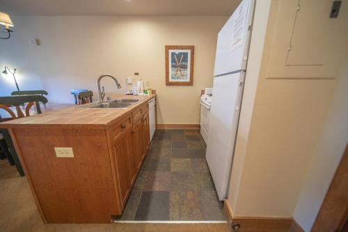 a kitchen with a sink and a refrigerator at Red Hawk Lodge 2297 by SummitCove Lodging in Keystone