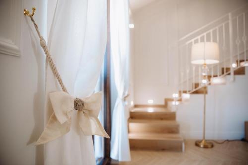 a white curtain with a bow in a room at Camilla Luxury Home in Nemi