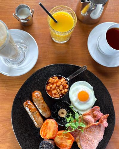 a plate of breakfast food on a wooden table at Morley Hayes Hotel in Derby