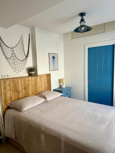 Un dormitorio con una cama y una puerta azul. en La medusa flamenca, en Santa Pola