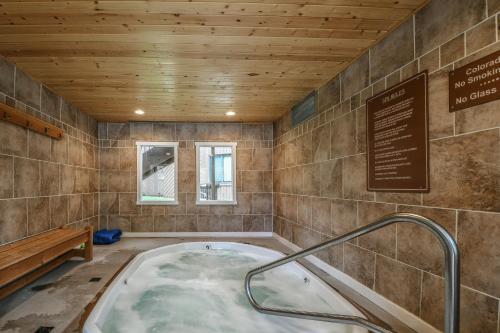 a jacuzzi tub in a room with a wooden ceiling at Wild Irishman 1043 by SummitCove Lodging in Keystone