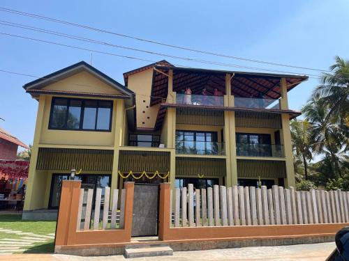 a house with a wooden fence in front of it at illa - By the sea in Udupi