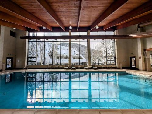 a large swimming pool in a building with a large window at Pines 2129 by SummitCove Lodging in Keystone