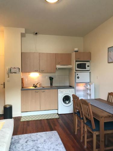 une cuisine avec une table et une cuisinière four supérieur dans l'établissement T2 Centre de Luchon, à Luchon