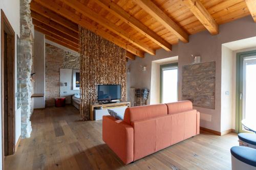 a living room with a couch and a tv at B&B La Pentola dei Sogni in Scanzorosciate